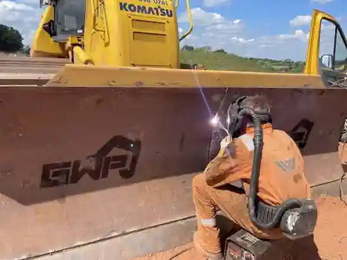 Dozer Blade Skin Welding. Employee Welding Dozer Blade Skin